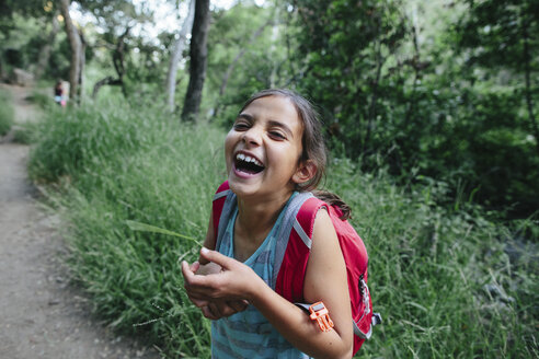 Porträt eines lachenden Mädchens im Wald stehend - CAVF41865