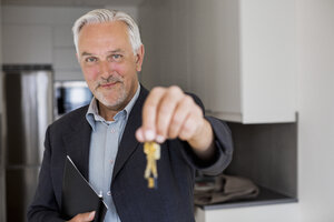 Porträt eines selbstbewussten Immobilienmaklers, der die Schlüssel für sein neues Haus in der Hand hält - MASF04817