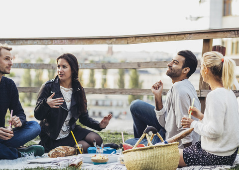 Multiethnische Freunde feiern eine Party im Dachgarten, lizenzfreies Stockfoto