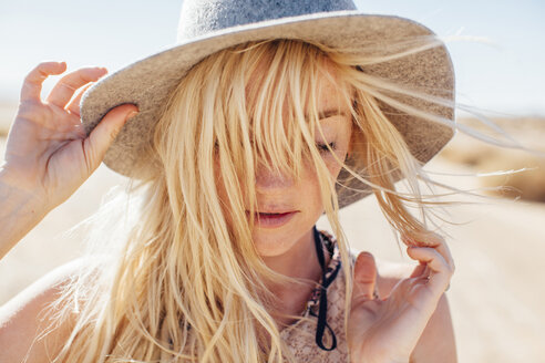 Nahaufnahme einer Frau mit Sonnenhut, die ihren Urlaub in der Wüste an einem sonnigen Tag genießt - CAVF41886