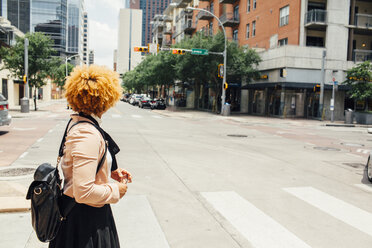 Seitenansicht einer Frau mit Tasche auf einer Straße in der Stadt an einem sonnigen Tag - CAVF41912