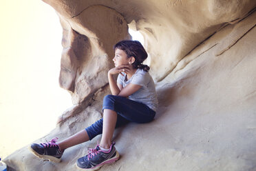 Thoughtful girl sitting in cave - CAVF41992