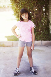 Portrait of confident girl standing on floor against trees - CAVF41997