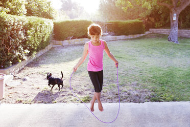 Girl jumping with rope on field - CAVF41999