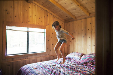 Glückliches Mädchen springt auf dem Bett - CAVF42005