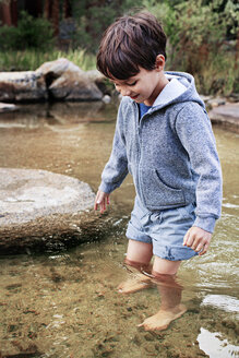 Glücklicher Junge im Wasser stehend am Bach - CAVF42009