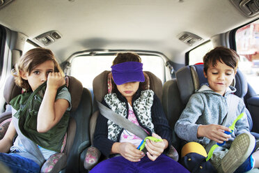 Close-up of siblings sitting in car - CAVF42016