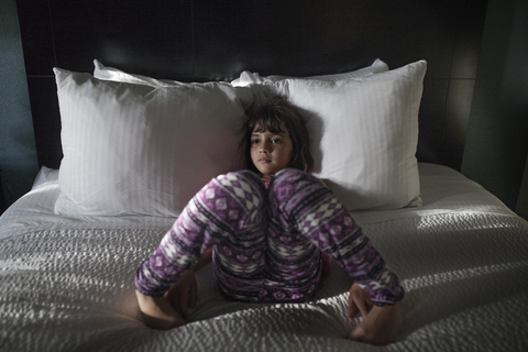 Hohe Winkel Ansicht von Mädchen auf dem Bett liegend, lizenzfreies Stockfoto