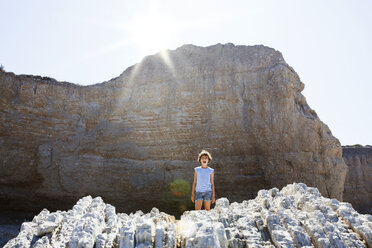 Vorderansicht eines Mädchens, das auf einem Felsen steht, gegen den Himmel an einem sonnigen Tag - CAVF42072