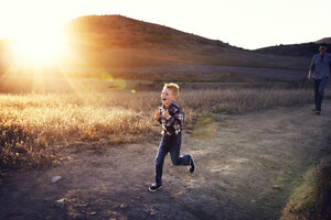 Junge läuft auf Feld an sonnigem Tag - CAVF42082