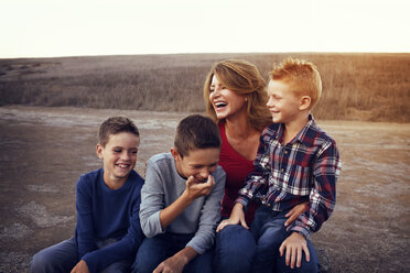 Glückliche Familie genießt auf dem Feld gegen den klaren Himmel - CAVF42094