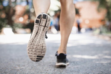 Niedriger Ausschnitt einer Frau in Sportschuhen, die auf einer Parkstraße läuft - MASF04855