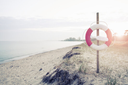 Rettungsring hängt an einer Stange am Strand an einem sonnigen Tag - MASF04883