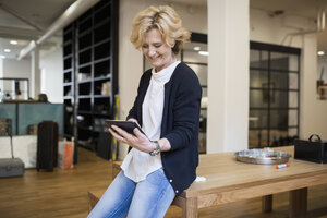 Reife Geschäftsfrau mit digitalem Tablet am Schreibtisch im Büro - MASF04891