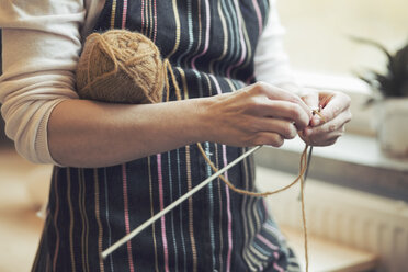 Midsection of woman knitting at home - MASF04897