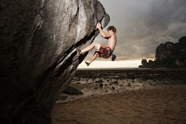 Side view of rock climber climbing on boulder - CAVF42149
