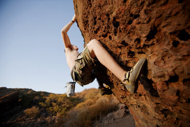 Low angle view of man climbing on rocks - CAVF42152