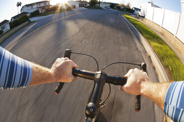 Ausgeschnittenes Bild eines Mannes, der auf der Straße Fahrrad fährt - CAVF42186