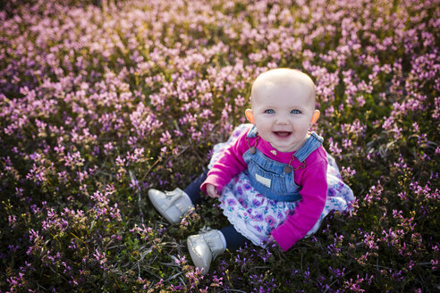 Hohe Winkel Porträt des glücklichen Baby Mädchen sitzt auf Feld - CAVF42332