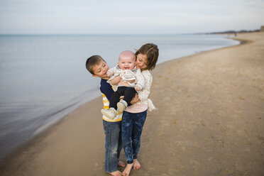 Geschwister genießen am Strand gegen bewölkten Himmel - CAVF42348