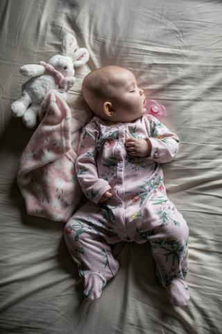 Draufsicht auf ein kleines Mädchen, das zu Hause auf dem Bett schläft, lizenzfreies Stockfoto