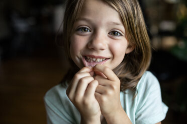 Porträt eines glücklichen Mädchens mit Zahnlücke zu Hause - CAVF42374