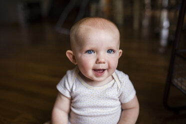 Portrait of happy baby girl sitting at home - CAVF42382