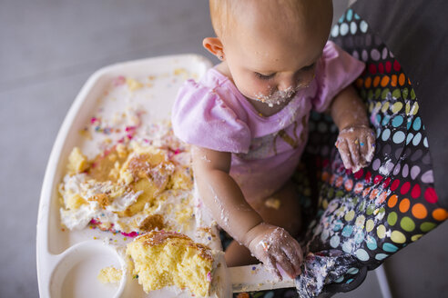 Hohe Winkel Ansicht von Baby-Mädchen spielen mit Essen, während auf Hochstuhl zu Hause sitzen - CAVF42405