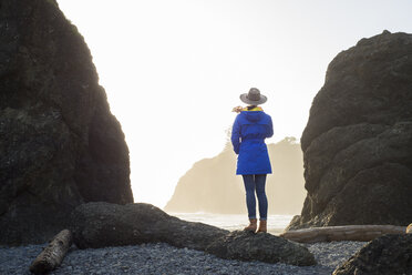 Rückansicht einer Wanderin, die am Ruby Beach vor einem klaren Himmel steht - CAVF42511