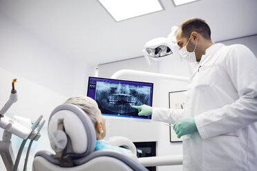 Zahnärztin erklärt einer Patientin in der Klinik das Röntgenbild - CAVF42566