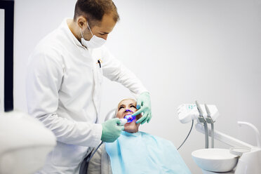 Dentist examining patient's teeth at clinic - CAVF42567