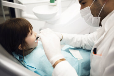 Männlicher Zahnarzt analysiert die Zähne eines Mädchens in der Klinik - CAVF42580