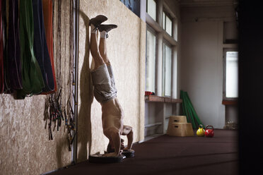 Junger Sportler beim Handstand in der Turnhalle - CAVF42592