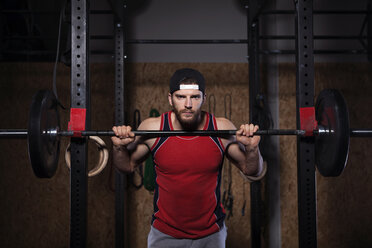 Portrait of man lifting barbells in gym - CAVF42594