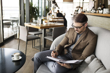 Businessman planning while sitting in cafe - CAVF42606