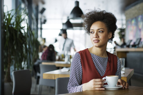 Nachdenkliche Frau mit Kaffeetasse in einem Cafe - CAVF42622