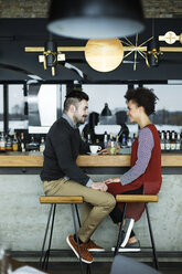 Business couple sitting face to face at cafe counter - CAVF42625