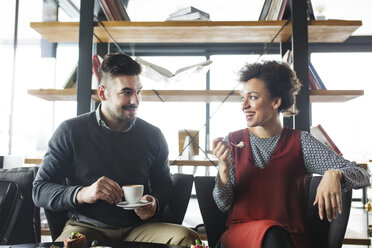 Glückliches Geschäftspaar mit Obst und Kaffee im Restaurant - CAVF42662