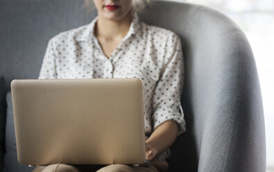 Midsection of businesswoman working on laptop at restaurant - CAVF42672