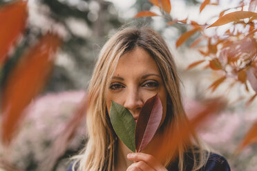 Portrait of young woman with two leaves - AFVF00436