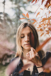 Porträt einer jungen Frau mit Herbstblatt - AFVF00439