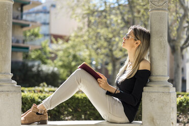 Junge Frau mit Notebook entspannt auf Bank - AFVF00448