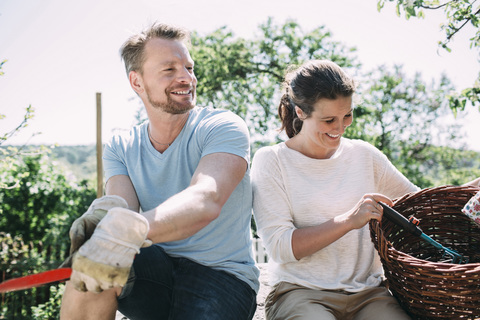 Glückliches Paar entspannt sich bei der Gartenarbeit im Garten, lizenzfreies Stockfoto
