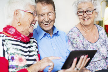 Fröhliche Seniorenfreunde nutzen digitales Tablet im Pflegeheim - MASF04952