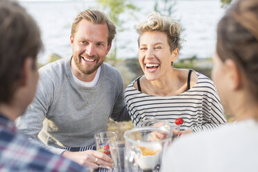 Glückliche Freunde genießen ihr Mittagessen am Picknicktisch - MASF04965