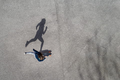 Frau beim Longboarden, Ansicht von oben, lizenzfreies Stockfoto