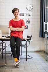 Full length portrait of smiling young businessman with arms crossed in new office - MASF04997