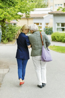 Rückansicht in voller Länge einer liebevollen Hausmeisterin und einer älteren Frau auf der Straße - MASF05013
