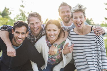 Group portrait of happy friends enjoying picnic at lakeshore - MASF05024