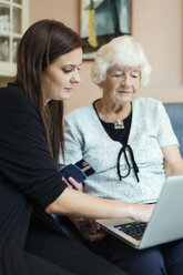 Großmutter und Enkelin benutzen Laptop zu Hause - MASF05028